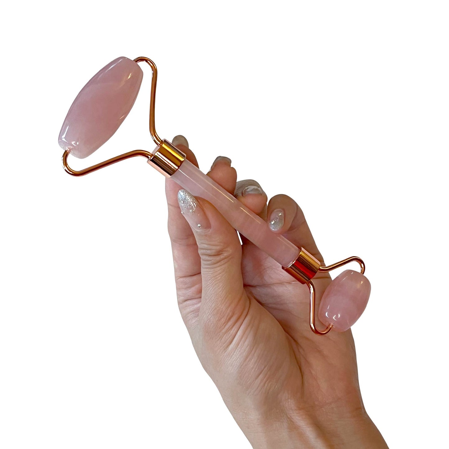 Hand holding a rose quartz roller, designed for facial massage and enhancing skin radiance.
