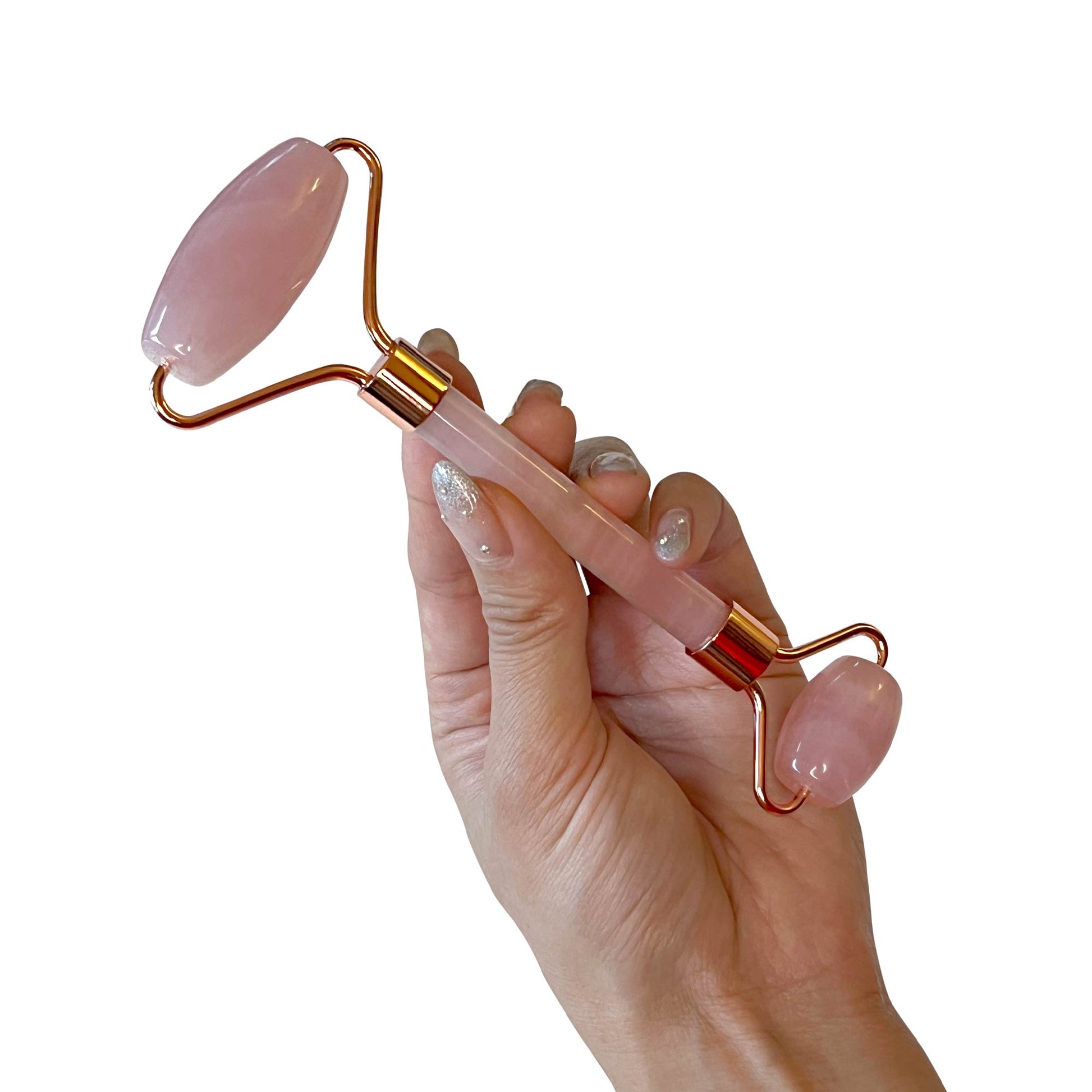 Hand holding a rose quartz roller, designed for facial massage and enhancing skin radiance.